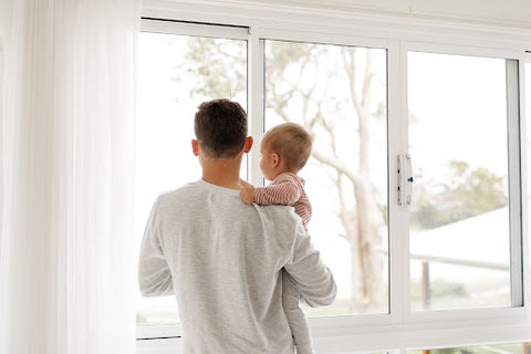 Dad and baby looking out the window.