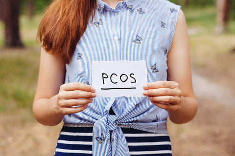 PCOS - Polycystic ovary syndrome, woman hormone sickness lettering on paper in woman's hands