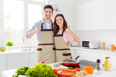 Two people romantic couple lovers chef gourmet man woman enjoy hobby weekend preparation tasty meal dinner approve show thumb-up sign in kitchen house indoors