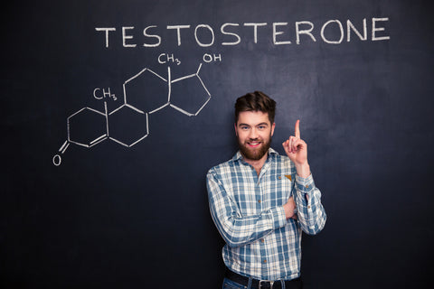 Confident smiling young man pointing up on chemical structure of testosterone molecule drawn on chalkboard background
